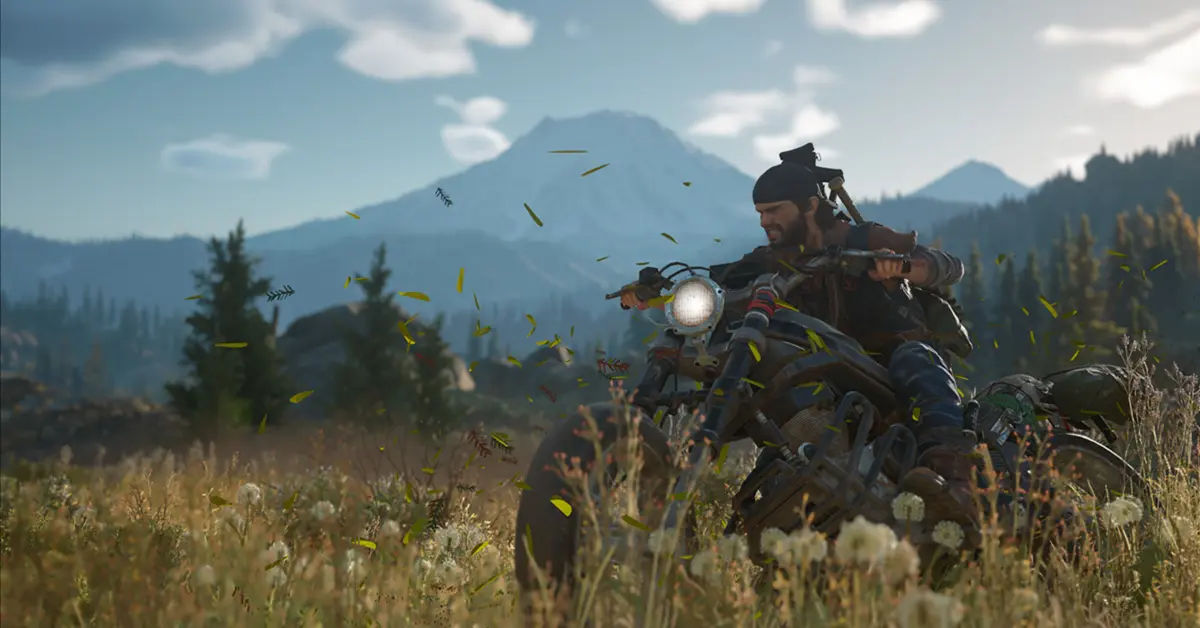 Deacon St. John pilotant sa moto de nomade lourdement modifiée à travers une forêt luxuriante mais dangereuse du Nord-Ouest Pacifique dans Days Gone.
