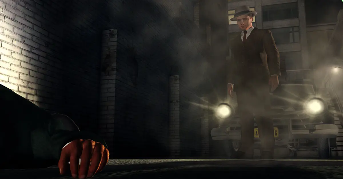 L.A. Noire : le détective Cole Phelps debout dans une rue des années 1940 sombrement éclairée
